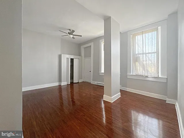 a view of empty room with wooden floor