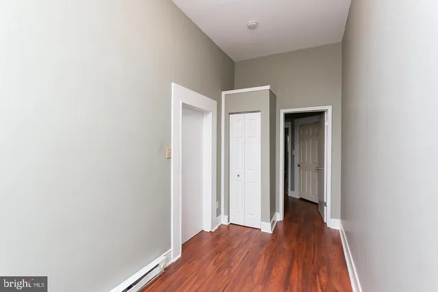 a view of a hallway with wooden floor