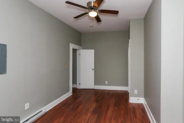 a view of room with hardwood floor and a ceiling fan