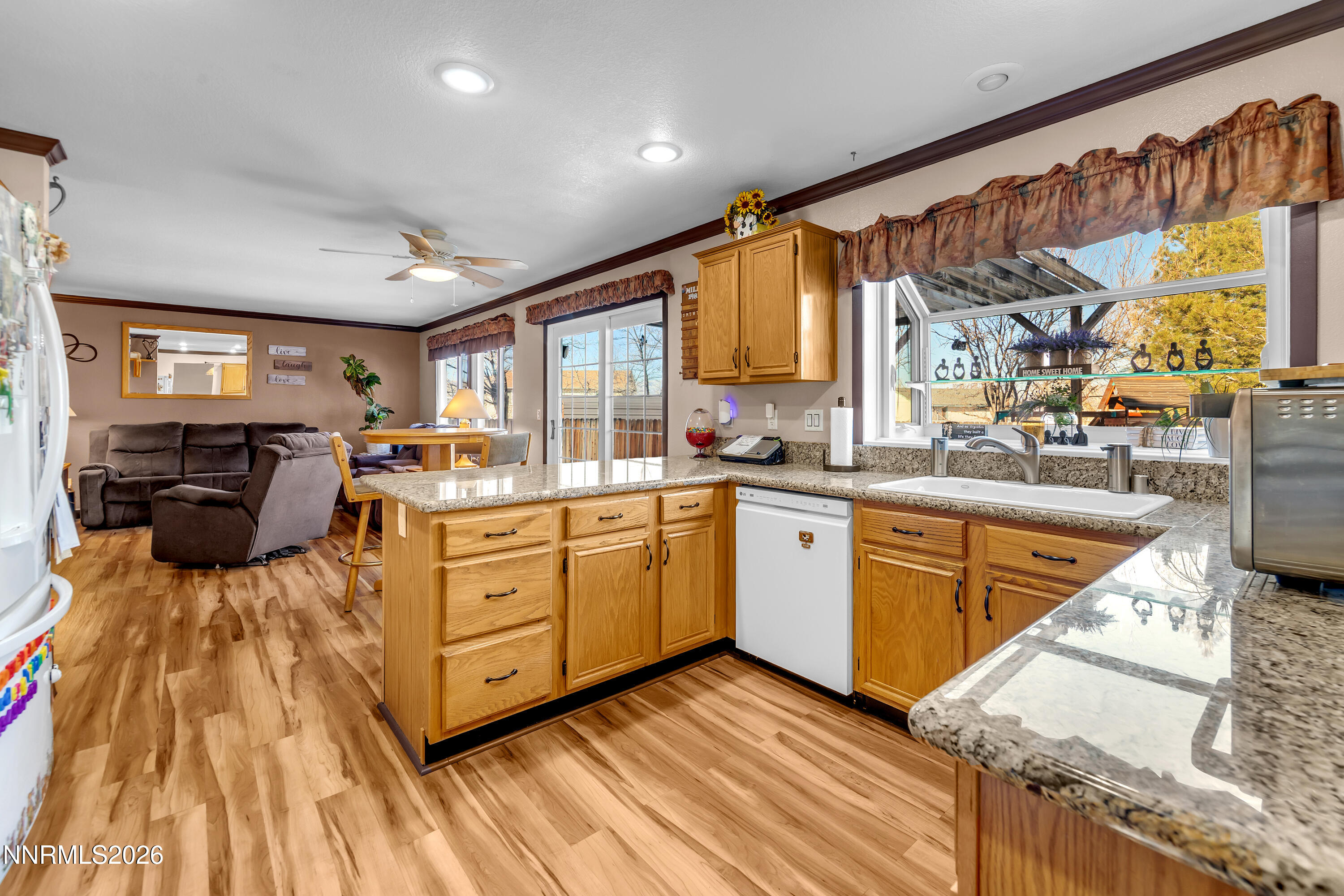 7879 White Falls Court Reno, NV 89506 - Photo 10 of 42 a kitchen with stainless steel appliances granite countertop lots of counter top space and wooden floor