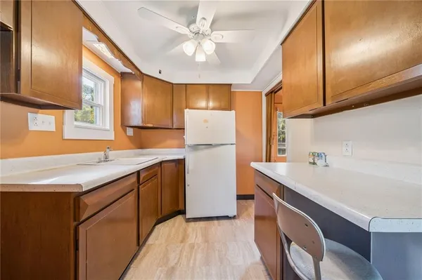 a kitchen with a sink a refrigerator and a stove top oven with a dishwasher