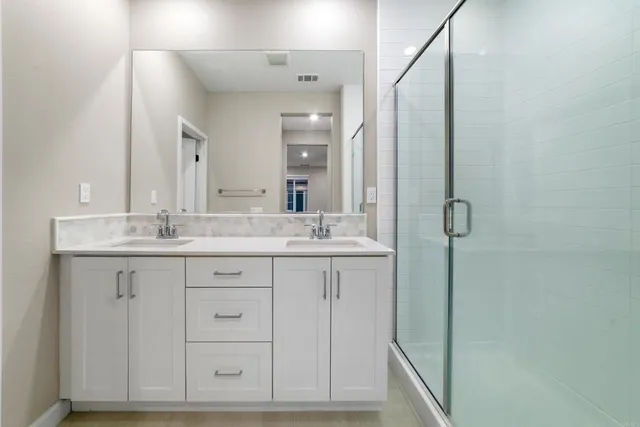 a bathroom with double sink and a mirror