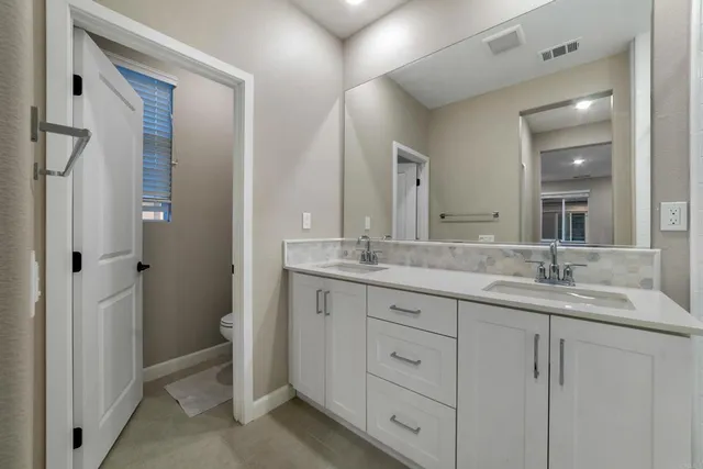 a bathroom with a double vanity sink mirror and shower