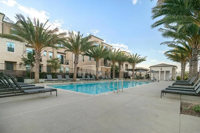a view of a swimming pool with a patio and a yard