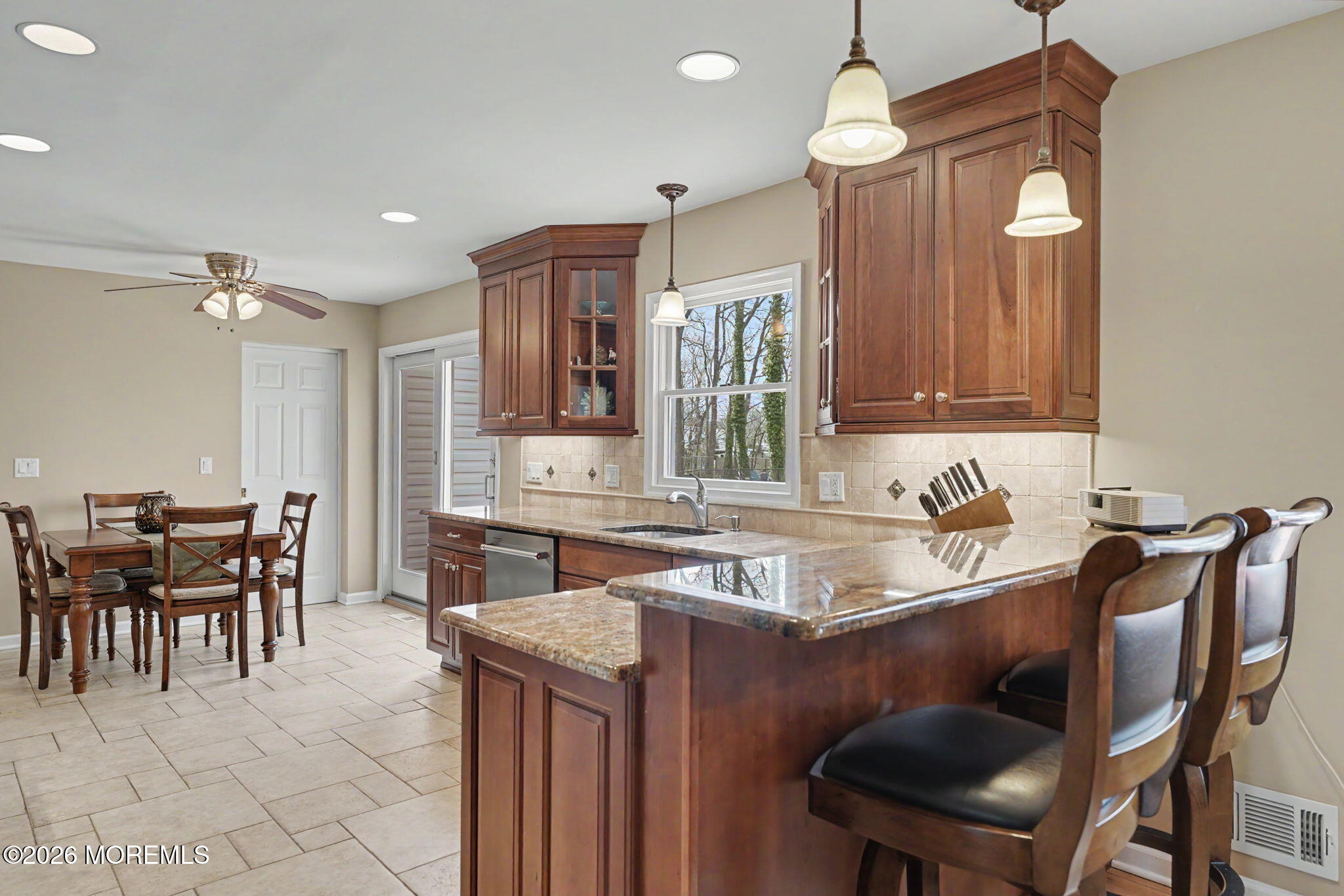 49 Hampton Drive Freehold, NJ 07728 - Photo 9 of 34 a kitchen with a dining table chairs cabinets and stainless steel appliances
