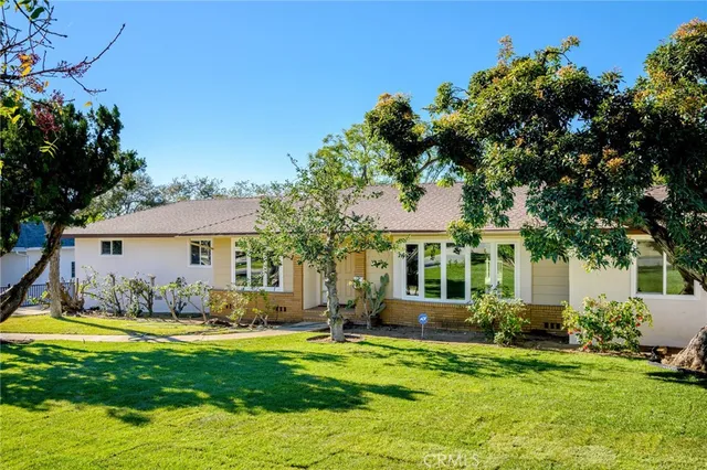 a front view of a house with a garden and yard