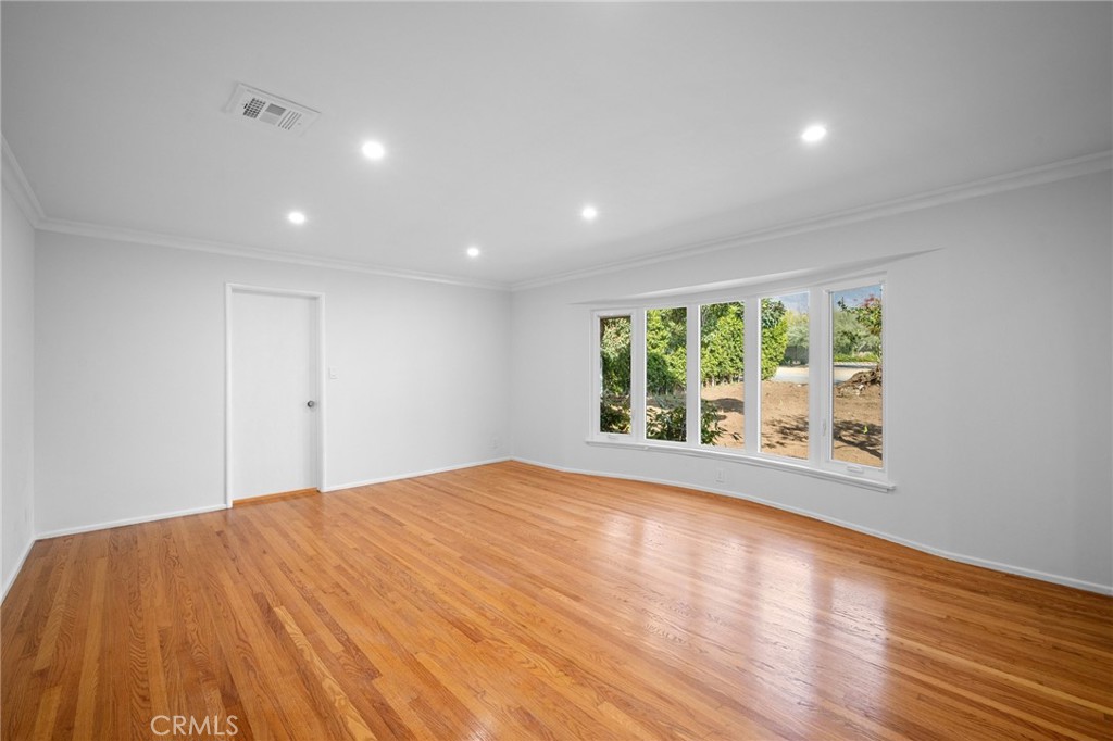685 Rim Road Pasadena, CA 91107 - Photo 6 of 27 a view of an empty room with wooden floor and a window
