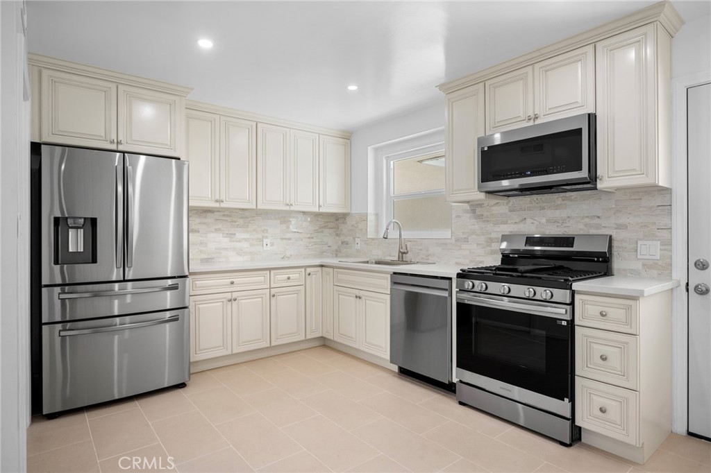 685 Rim Road Pasadena, CA 91107 - Photo 9 of 27 a kitchen with stainless steel appliances white cabinets white stove a microwave and a refrigerator