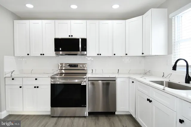 a kitchen with white cabinets and stainless steel appliances