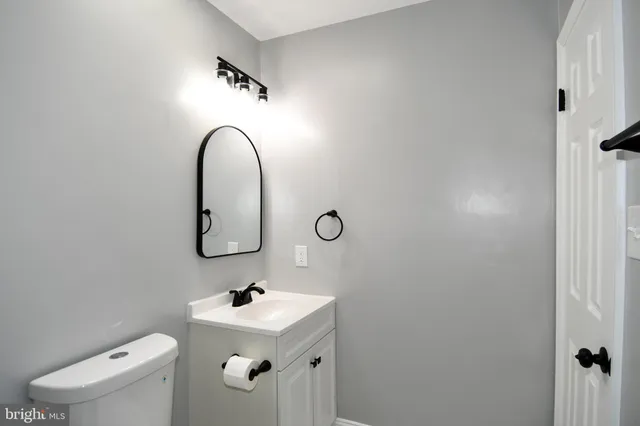 a bathroom with a sink and mirror with toilet