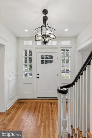 an empty room with wooden floor fireplace and windows