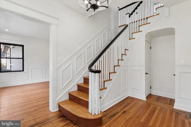 a view of an empty room with wooden floor and a fireplace