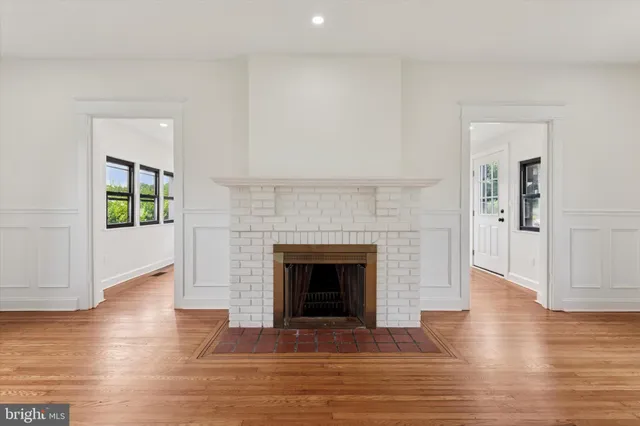 a view of a big room with wooden floor and windows