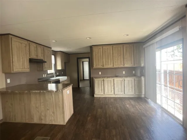 a kitchen with a refrigerator a stove top oven and wooden floor