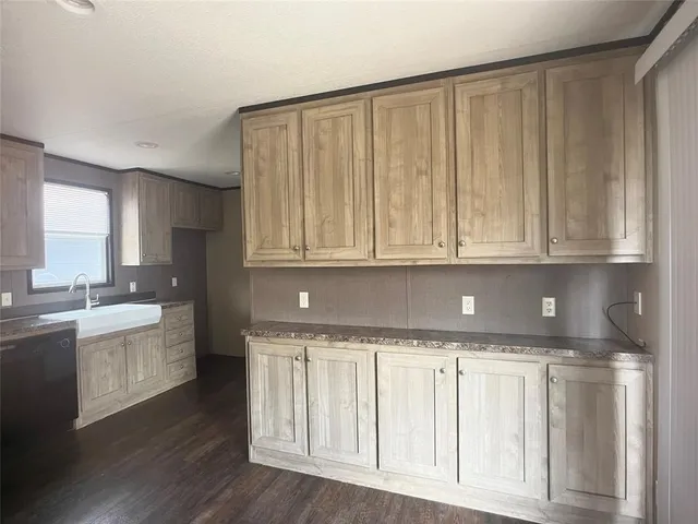 a view of a kitchen with granite countertop white cabinets and wooden floor