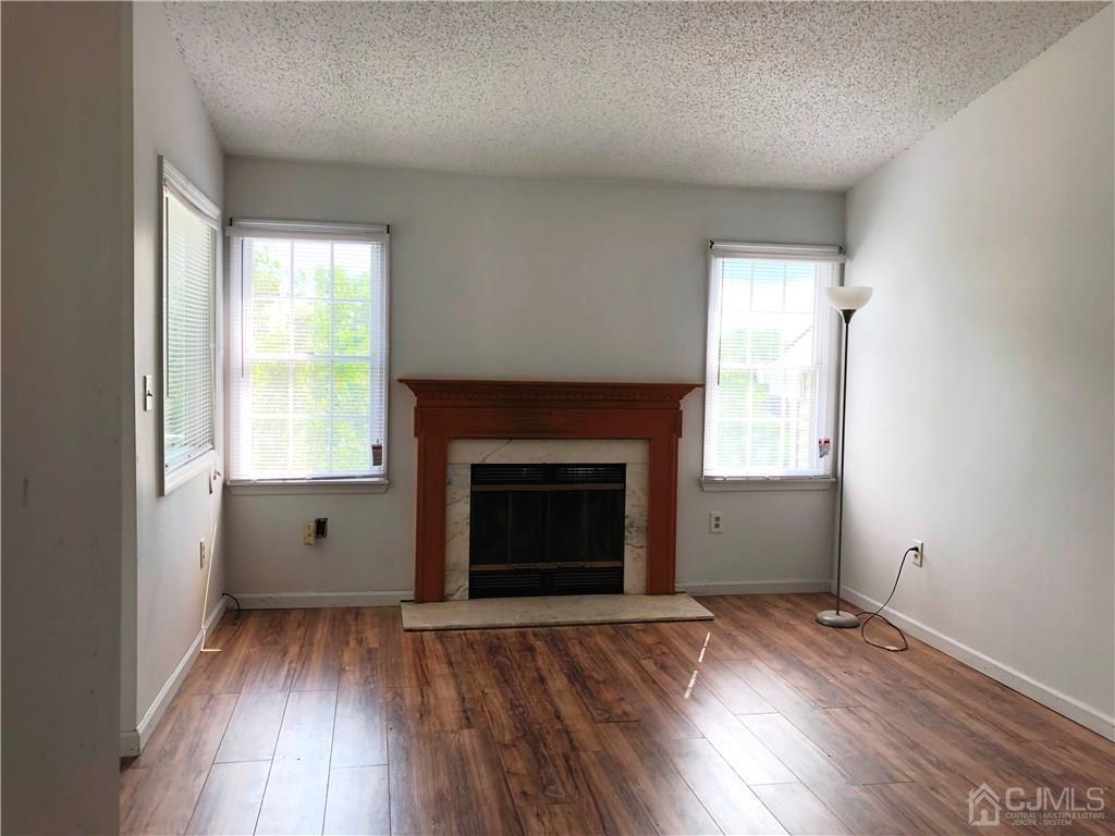 1237 Edpas Road, Unit 1237 New Brunswick, NJ 08901 - Photo 20 of 29 an empty room with wooden floor fireplace and windows