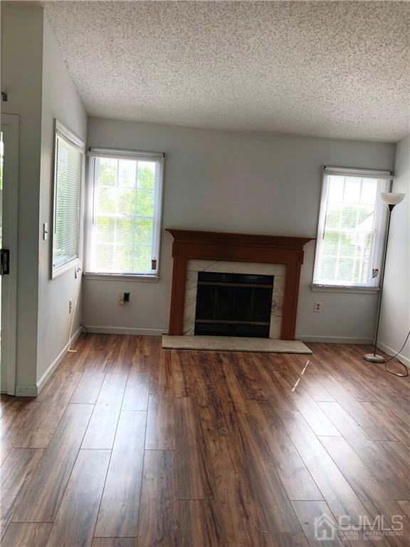 1237 Edpas Road, Unit 1237 New Brunswick, NJ 08901 - Photo 21 of 29 an empty room with wooden floor and fireplace