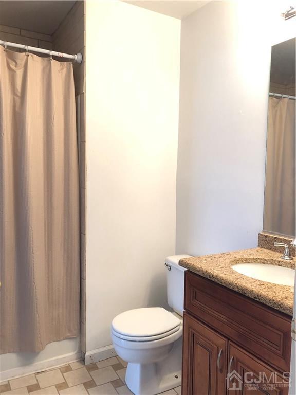 1237 Edpas Road, Unit 1237 New Brunswick, NJ 08901 - Photo 27 of 29 a bathroom with a granite countertop toilet and a sink