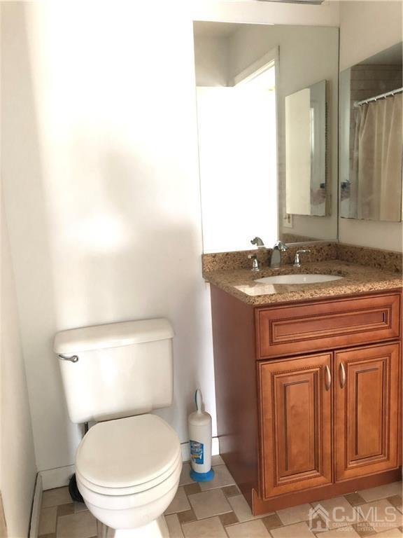 1237 Edpas Road, Unit 1237 New Brunswick, NJ 08901 - Photo 29 of 29 a bathroom with a granite countertop toilet sink and mirror