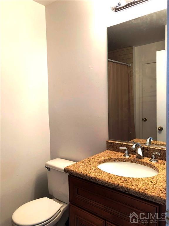 1237 Edpas Road, Unit 1237 New Brunswick, NJ 08901 - Photo 5 of 29 a bathroom with a granite countertop toilet sink and mirror