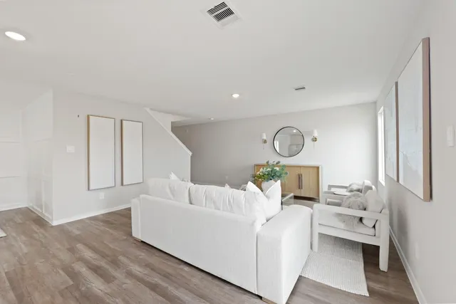 a living room with furniture and a wooden floor