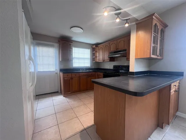 a kitchen with granite countertop a sink stainless steel appliances and cabinets