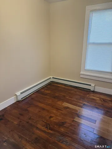 a view of a small space with wooden floor and a window