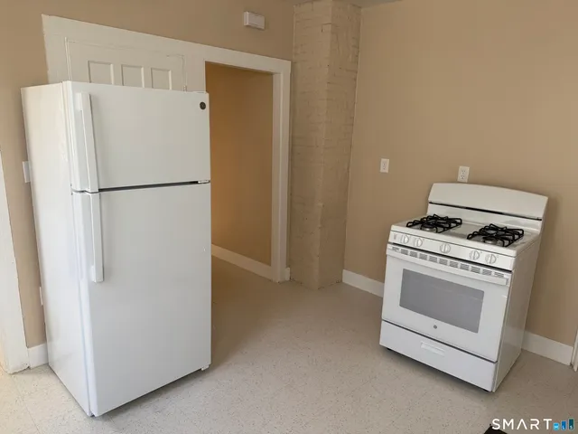 a white refrigerator freezer and a stove sitting inside of a kitchen