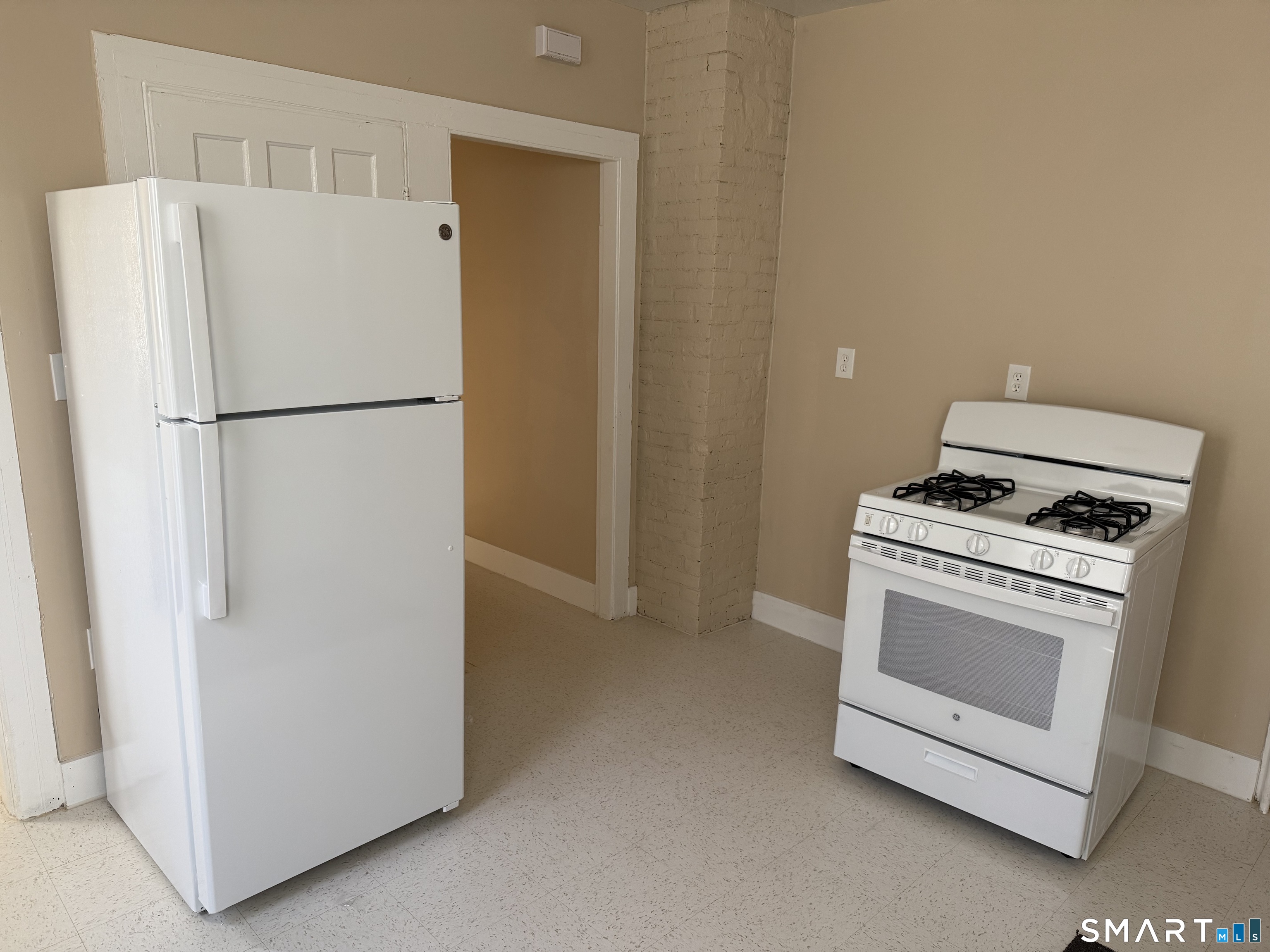 597 Ogden Street Bridgeport, CT 06608 - Photo 9 of 10 a white refrigerator freezer and a stove sitting inside of a kitchen