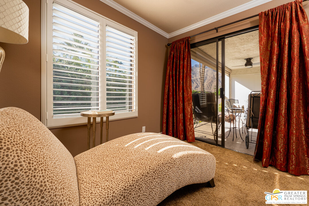 325 East Via Escuela, Unit 324 Palm Springs, CA 92262 - Photo 16 of 29 a bedroom with a bed and a large window