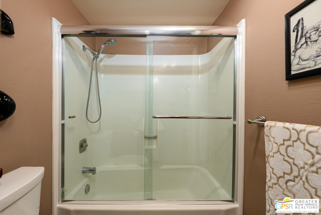 325 East Via Escuela, Unit 324 Palm Springs, CA 92262 - Photo 20 of 29 a bathroom with a glass shower door