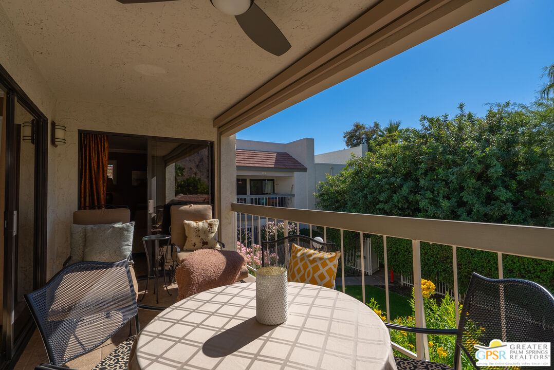 325 East Via Escuela, Unit 324 Palm Springs, CA 92262 - Photo 23 of 29 a view of a chair and tables in the balcony