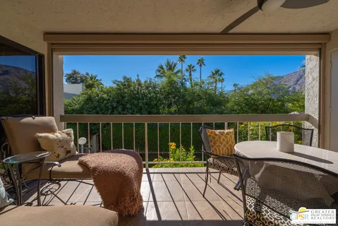 a balcony with wooden floor table and chairs