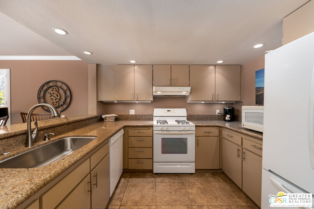 325 East Via Escuela, Unit 324 Palm Springs, CA 92262 - Photo 6 of 29 a kitchen with a sink stove and cabinets
