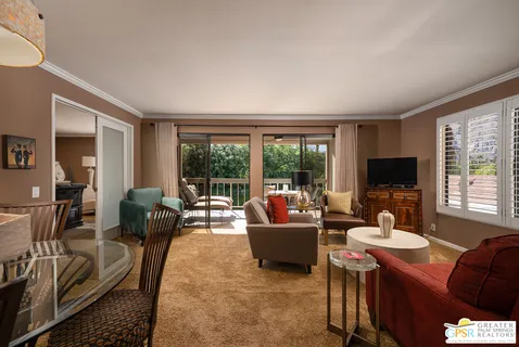 a living room with furniture a flat screen tv and a large window