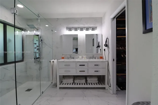 a bathroom with a double vanity sink mirror and shower
