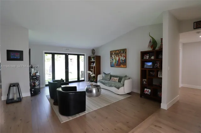 a living room with furniture large window and wooden floor