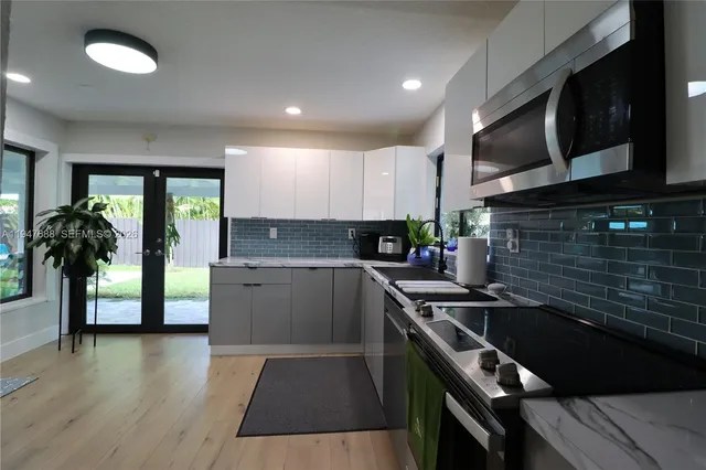 a kitchen with stainless steel appliances a sink a stove top oven a counter space and cabinets