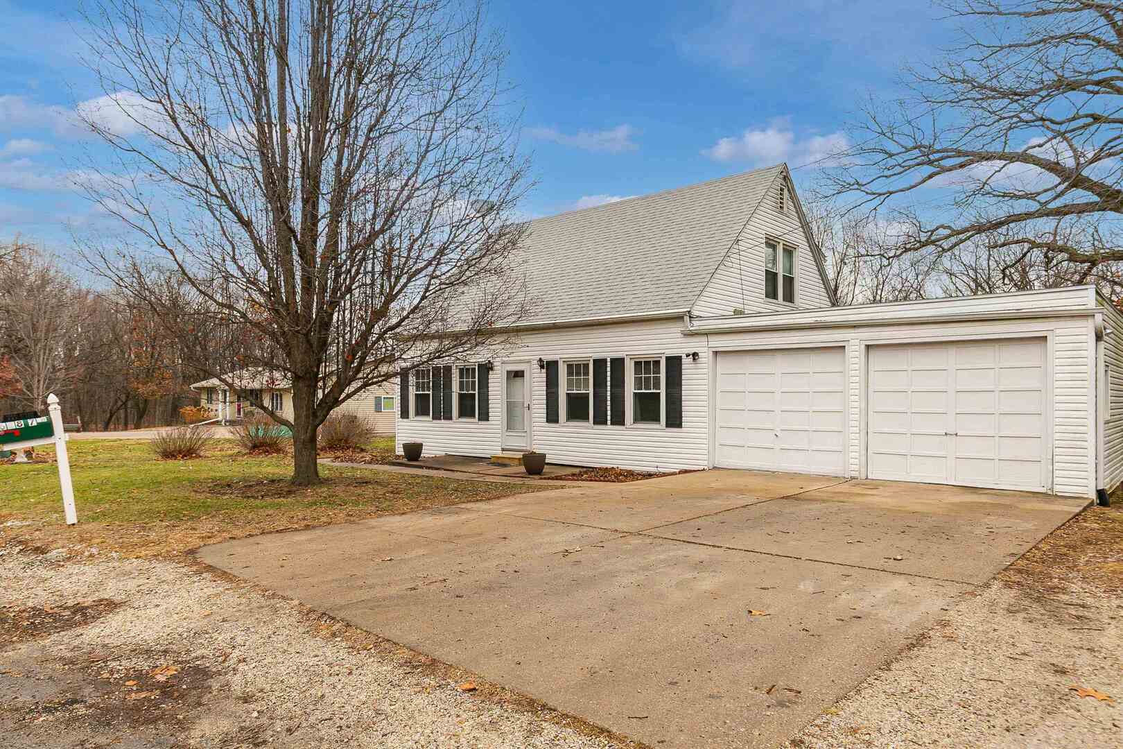 a view of a house with a yard and large tree