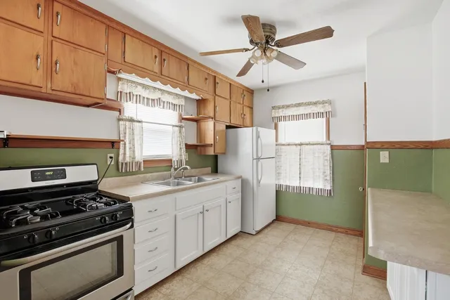 a kitchen with stainless steel appliances granite countertop a stove a refrigerator and a cabinets