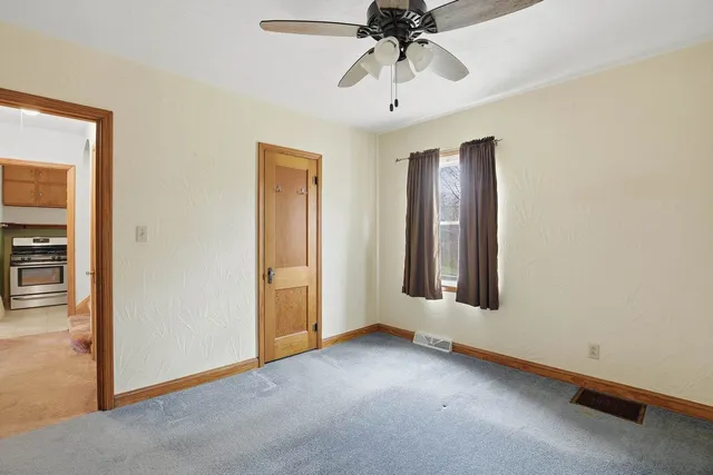 an empty room with windows and fan