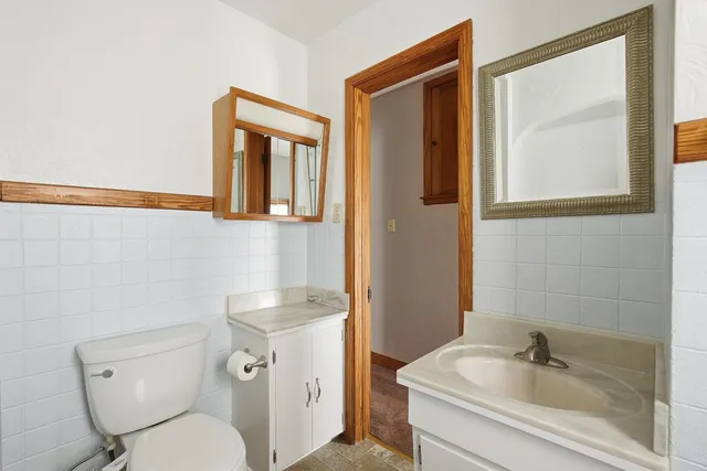 a bathroom with a toilet sink and mirror