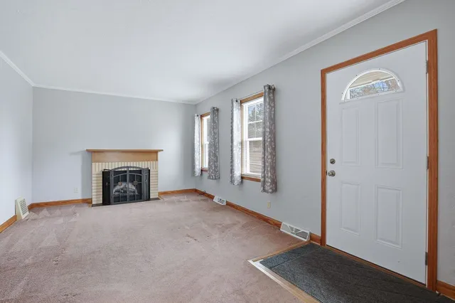 an empty room with windows and fireplace