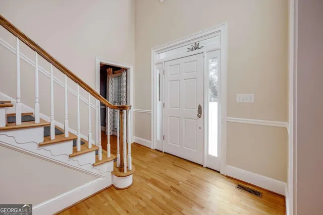 a view of entryway with wooden floor and front door