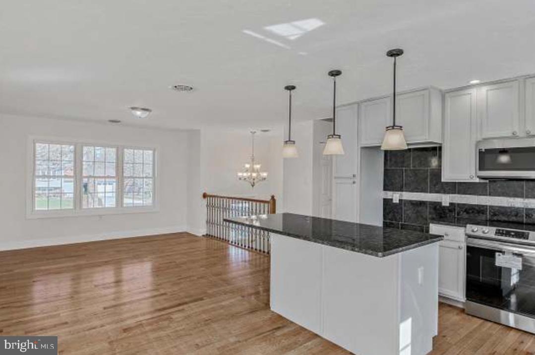 40 Sandy Court Hanover, PA 17331 - Photo 6 of 19 a large kitchen with stainless steel appliances granite countertop a stove a sink a refrigerator and white cabinets with wooden floor