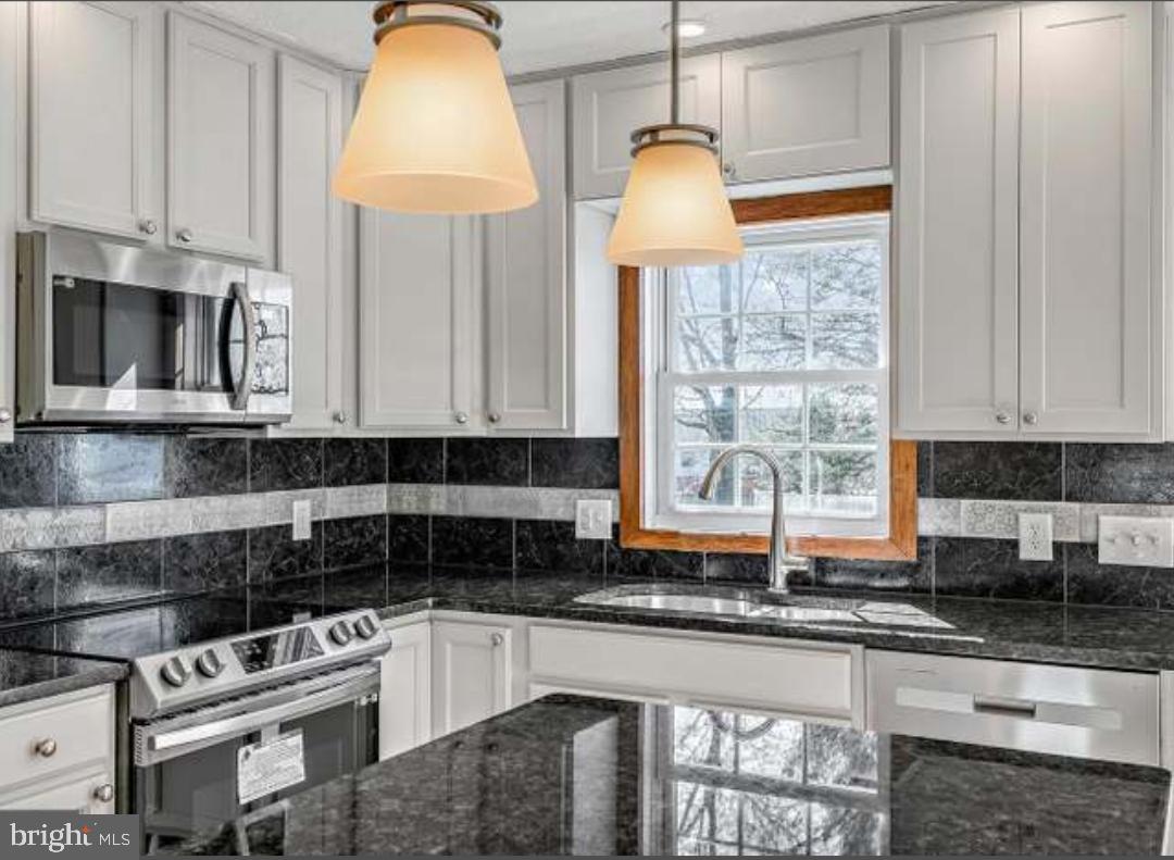 40 Sandy Court Hanover, PA 17331 - Photo 7 of 19 a kitchen with stainless steel appliances granite countertop a stove a sink and a microwave