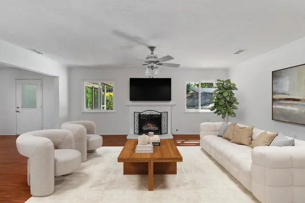 a living room with furniture a fireplace and a flat screen tv