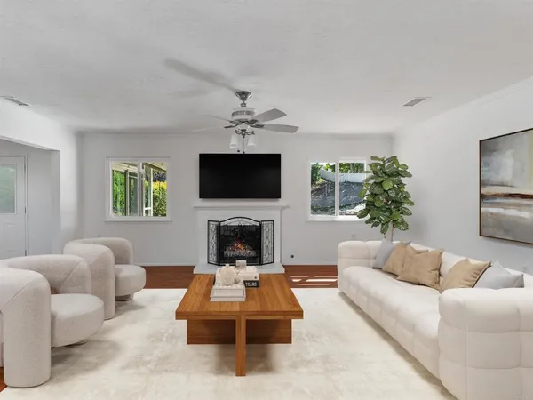 a living room with furniture a flat screen tv and a fireplace