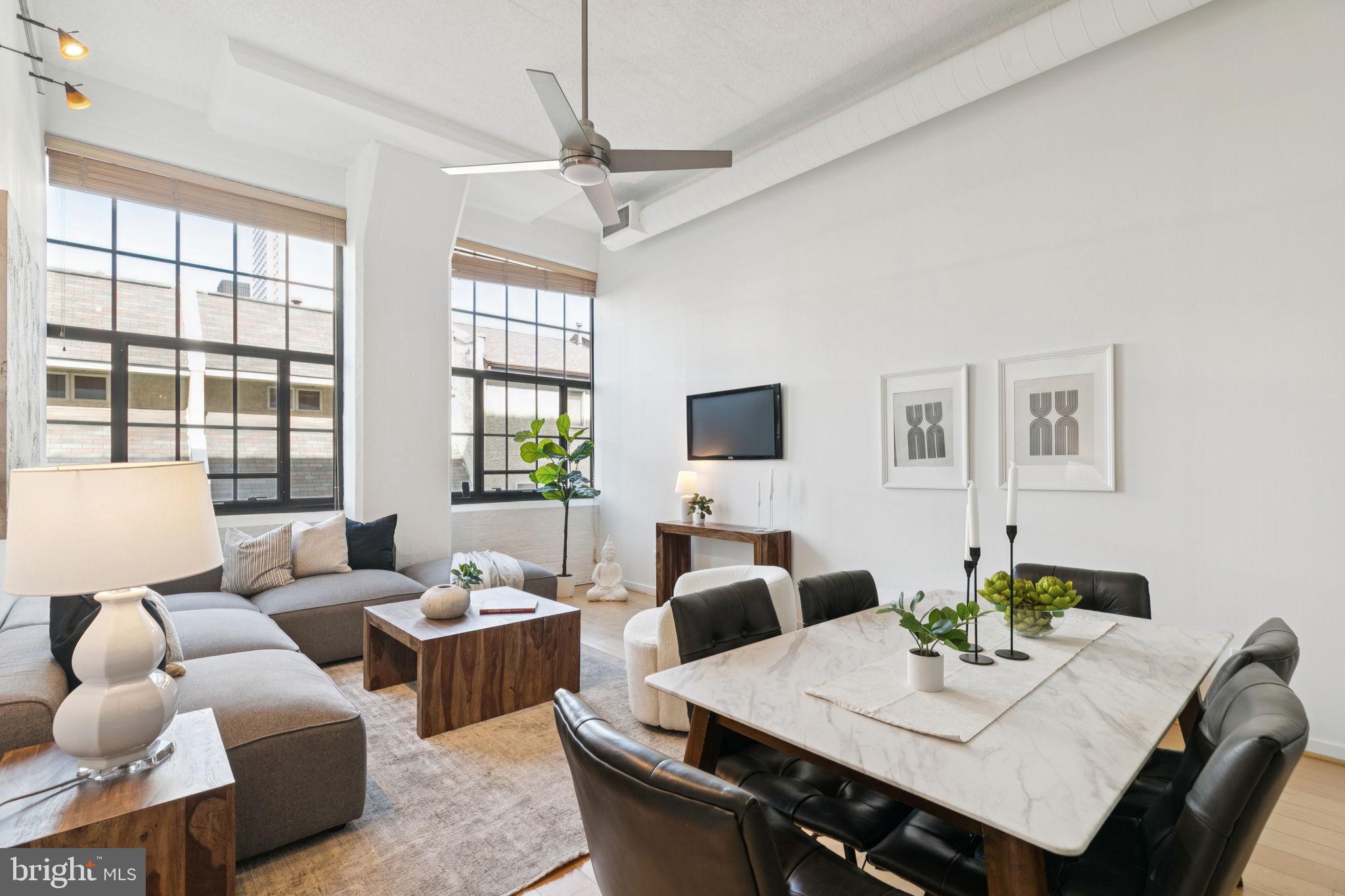 2429 Locust Street, Unit 318 Philadelphia, PA 19103 - Photo 2 of 35 a living room with furniture a chandelier and a table