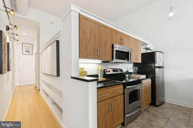 a kitchen with stainless steel appliances a stove microwave and refrigerator